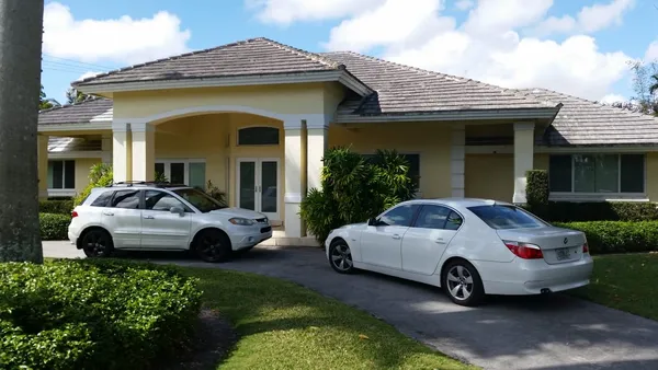Impact windows and doors - home view with cars parked outside.