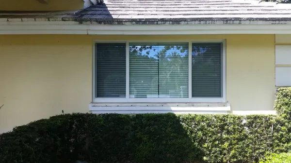 impact window building permits - yellow home with impact windows - Impact windows in Palm Beach County concept image