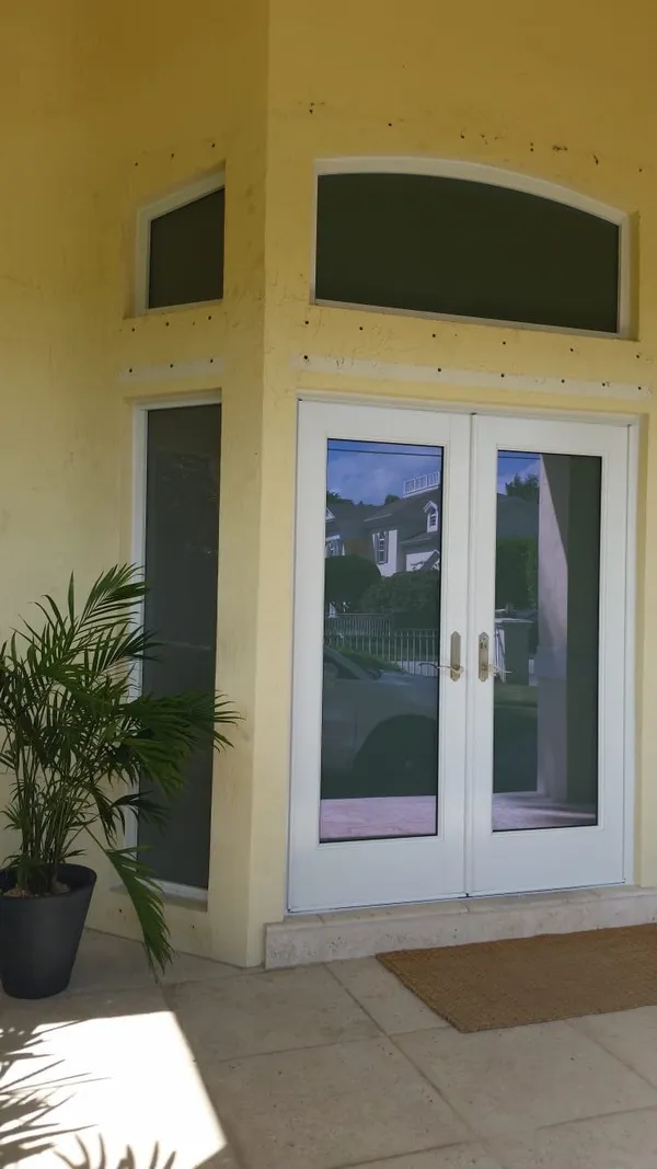 Impact windows and doors white door frame exterior view.