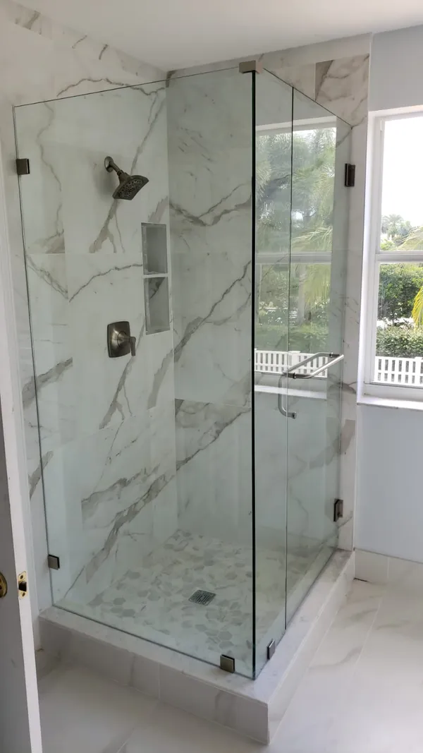while and grey marble in frameless showers on a sunny day